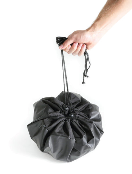 person holding change mat with contents inside that is tied shut 
