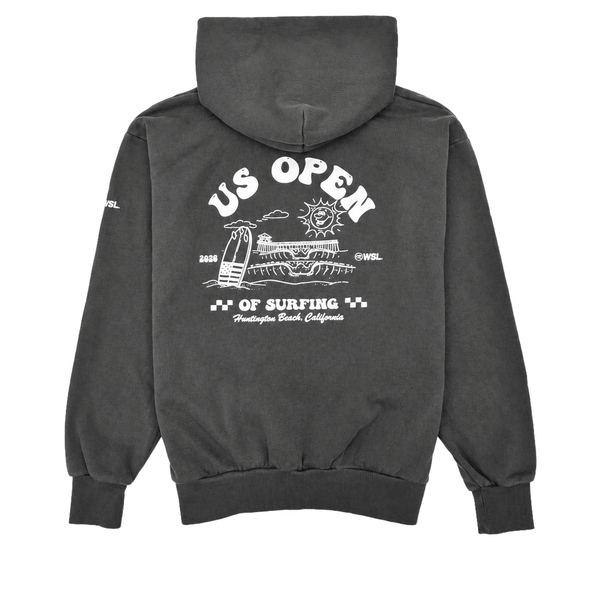 Back view of a charcoal heavyweight hooded sweatshirt featuring a large white US Open of Surfing graphic with a surfboard, ocean waves, sun illustration, and Huntington Beach Pier artwork. The pullover hoodie has a vintage-washed finish, ribbed cuffs and waistband, and is displayed on a clean white background.
