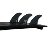 tail of black surfboard with 3 black surf fins on a white background
