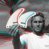 picture of ethan ewing holding 2 surf fins on a beach