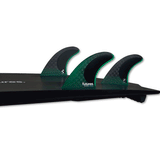 tail of black surfboard with 3 green fins