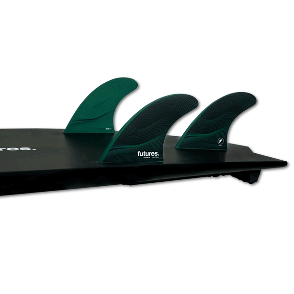 tail of black surf board with 3 green fins on a white background