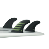tail of white surfboard with 3 fins attached