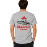 back of model wearing a light gray US Open of Surfing t-shirt laid flat. The back graphic features an illustration of the Huntington Beach Pier with bright red rooftops above bold red text reading "US Open of Surfing Huntington Beach California." The shirt is made from medium-weight cotton and showcases a clean surf-inspired design celebrating Huntington Beach's iconic surf culture.