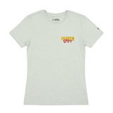 Women's light seafoam T-shirt shown from the front with a colorful 2026 US Open of Surfing script on the chest