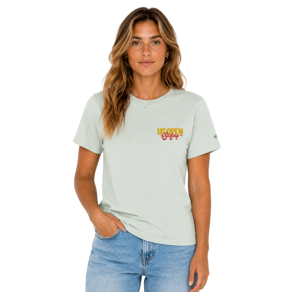 Women's light seafoam T-shirt shown from the front with a colorful 2026 US Open of Surfing script on the chest