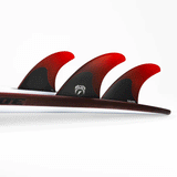 tail of surfboard with 3 surf fins attached