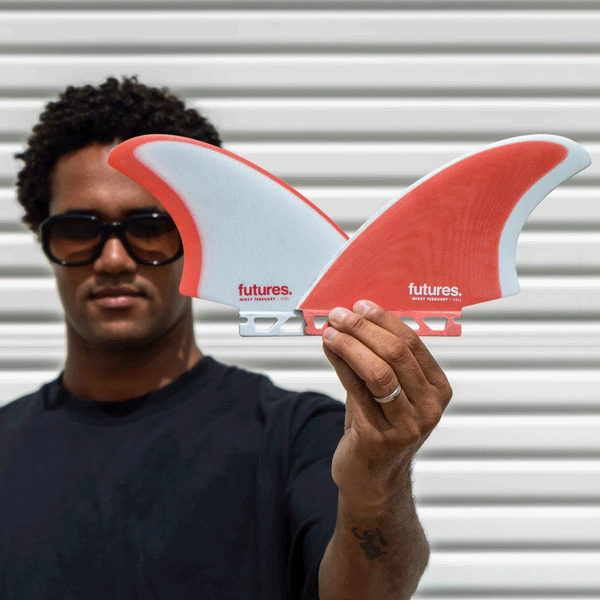 mikey february holding 2 surf fins