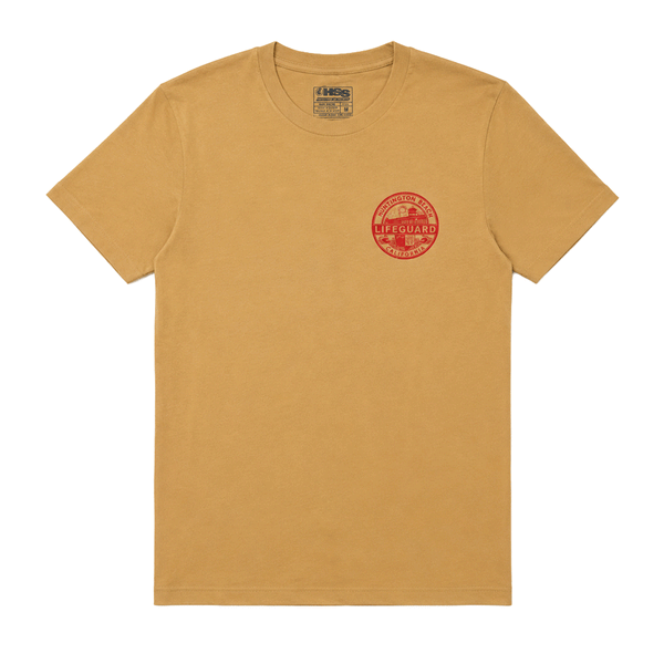 Front of tan Huntington Beach Lifeguard men's T-shirt with small red lifeguard emblem graphic.