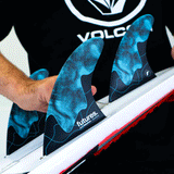 person installing surf fins to a surfboard