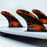 tail of surfboard with 3 surf fins attached