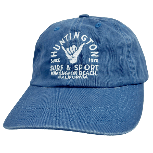 blue dad hat with white script and image of the shaka sign on white background