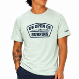 person wearing light green tshirt with grey US Open's Shield logo on white background