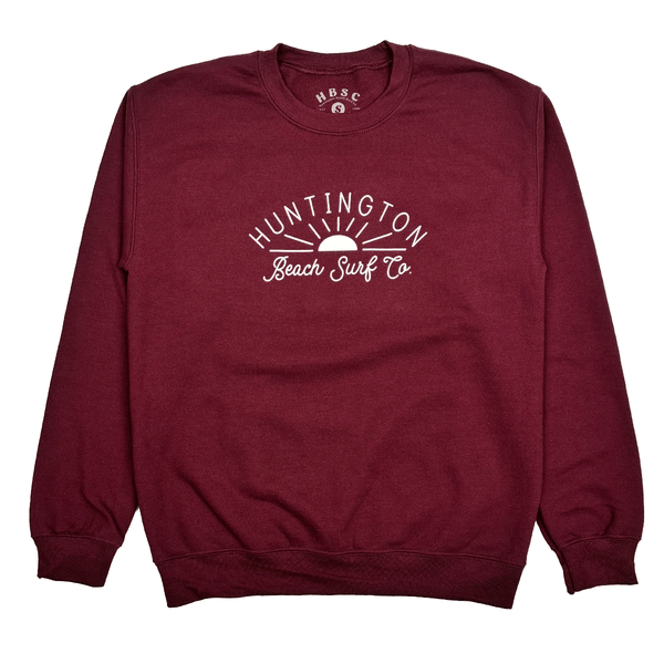 maroon crewneck sweatshirt with white script with sun. "huntington beach surf co."