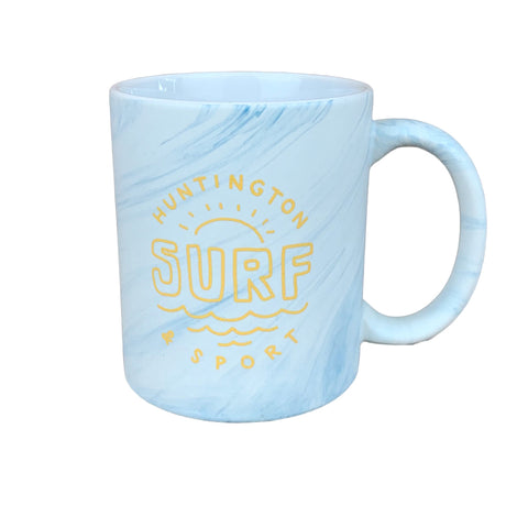 Light blue mug with yellow text on a wooden surface