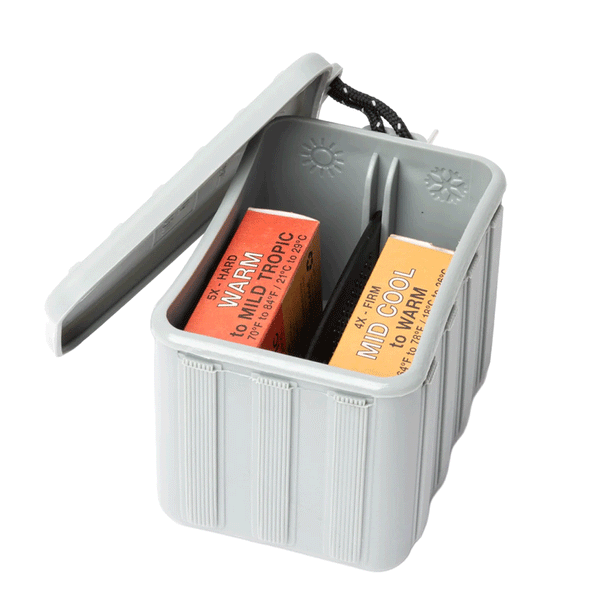grey tub with lid off and 2 bars of wax and surf comb inside tub