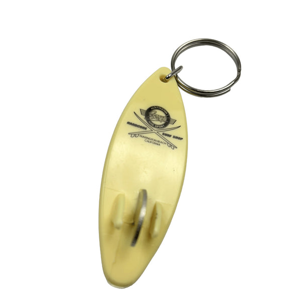 Yellow keychain shaped like a surfboard with a logo on a white background